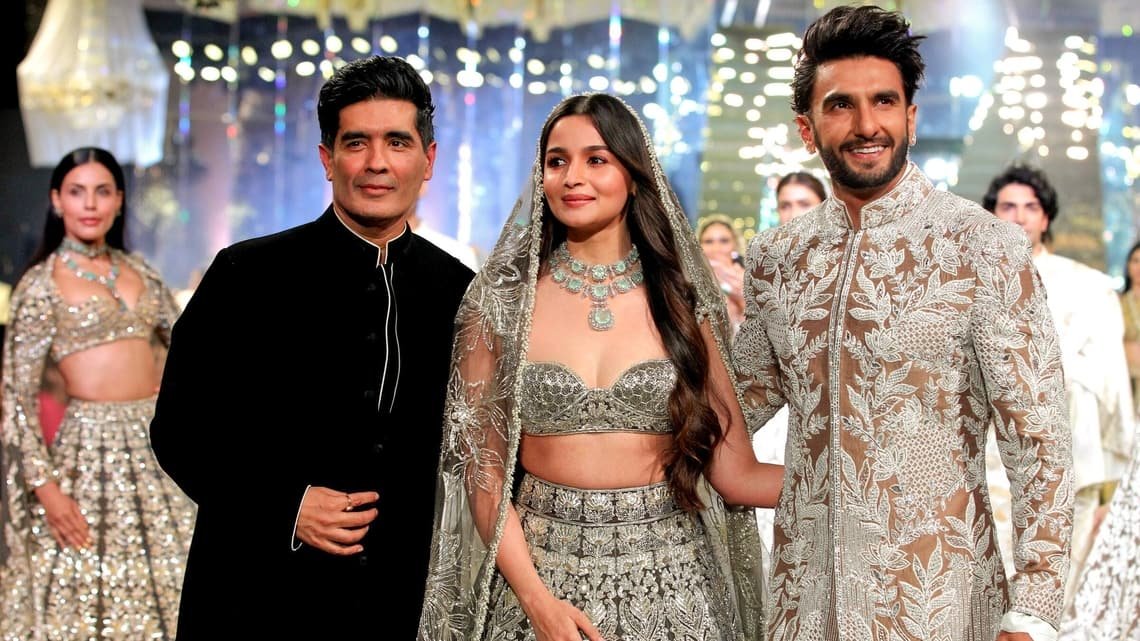 Actor Ranveer Singh and actress Alia Bhatt present a creation by designer Manish Malhotra (in black) during ‘The Bridal Couture show’, in Mumbai